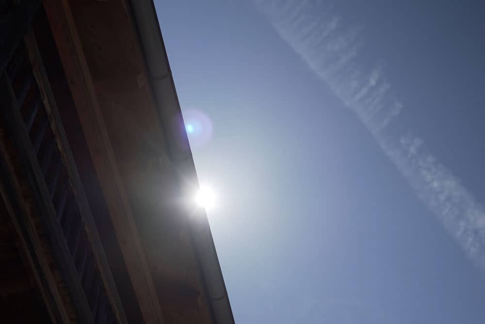 Sonne erscheint hinter einem Dach